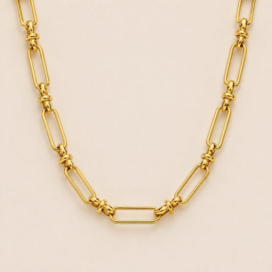 Gold paperclip-link chain necklace, the Iris NECKLACE, featuring elongated oval links joined by small round connectors, shown in close-up.