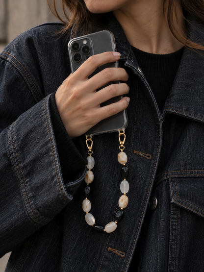 Folie à Trois Isolde SHORT PHONE CHAIN in black, cream and marbled tan beads, clipped to a phone held inside a denim jacket.