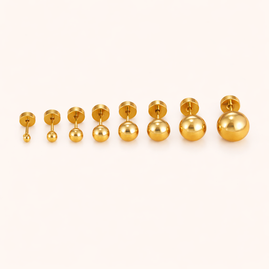The Jean PIERCING in gold, eight labret studs shown side by side in sizes ranging from small to large on cream.