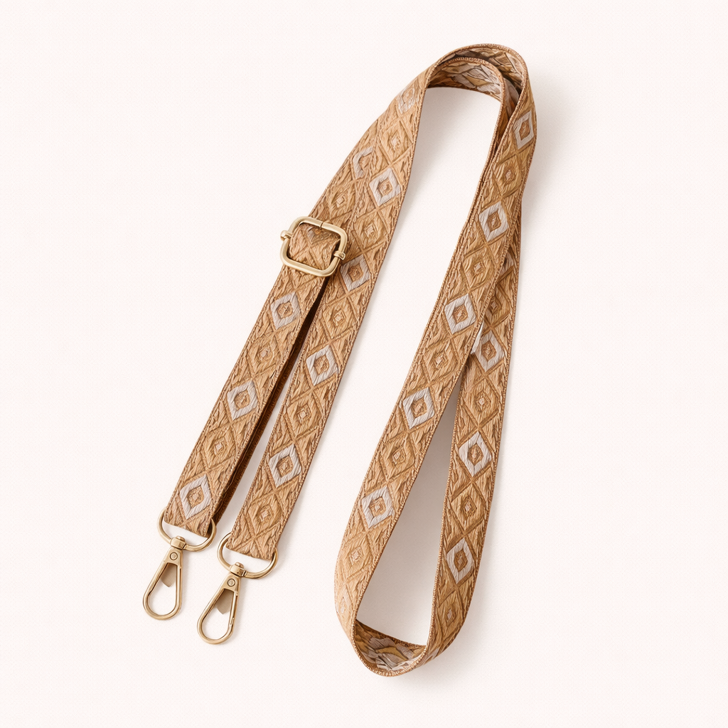 Woven Jetlag long phone strap in tan and cream neutral diamond pattern, coiled flat with gold clasps.