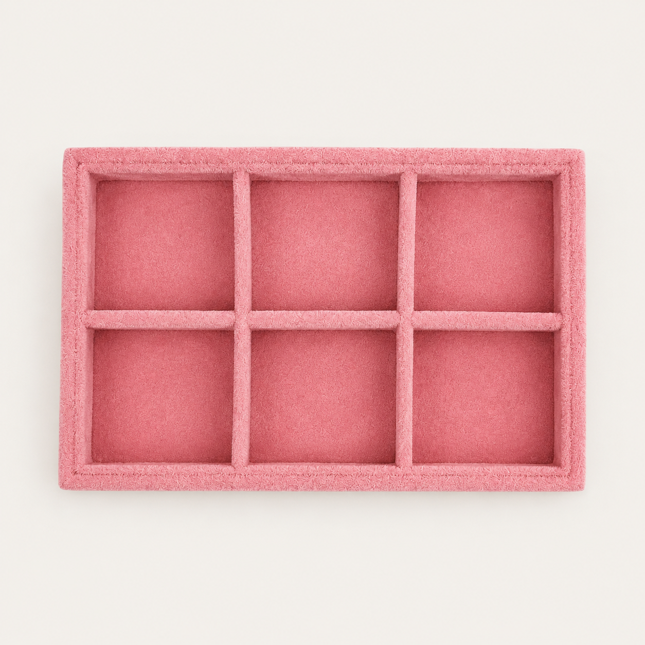 Small pink velvet jewelry tray with six square compartments for organizing earrings and small accessories.