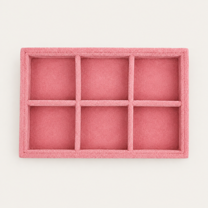 Small pink velvet jewelry tray with six square compartments for organizing earrings and small accessories.