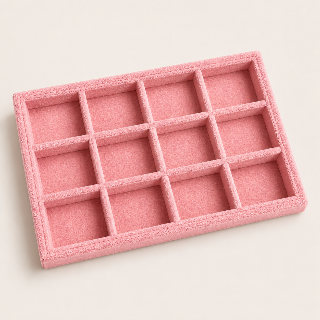 Medium pink velvet jewelry tray with twelve square compartments, shown at an angle for organizing rings and jewelry.