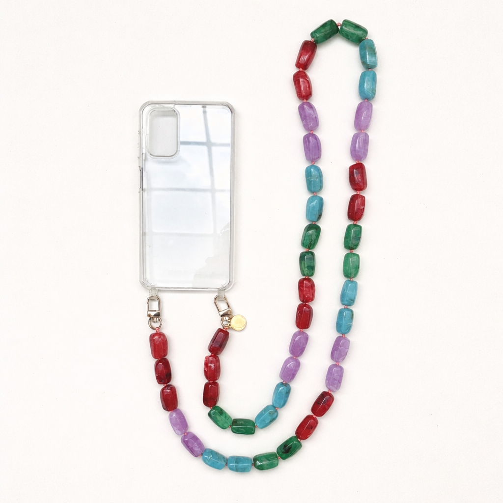 A clear phone case with a red, purple, teal, and green bead phone chain, shown on a cream background.