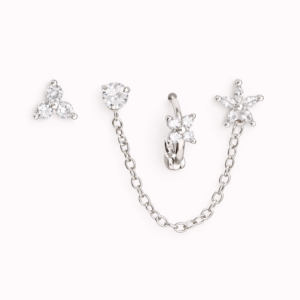 The Juno SET is shown in silver, with a trio stud, chain-linked stud, flower huggie, and star drop charm.