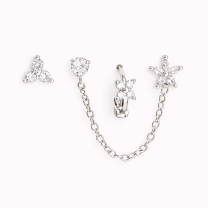 The Juno SET is shown in silver, with a trio stud, chain-linked stud, flower huggie, and star drop charm.