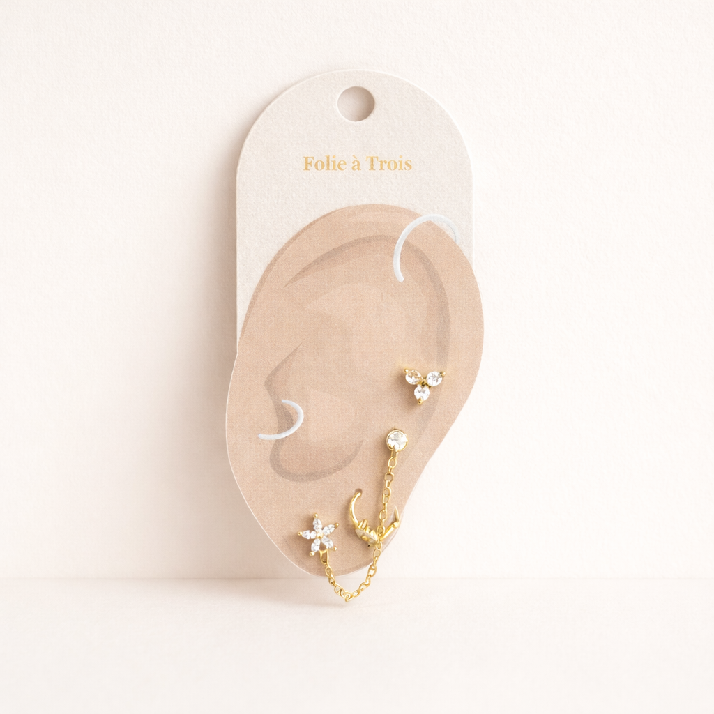 The Juno SET is displayed on a branded card shaped like an ear, showing the gold pieces and chain placement.