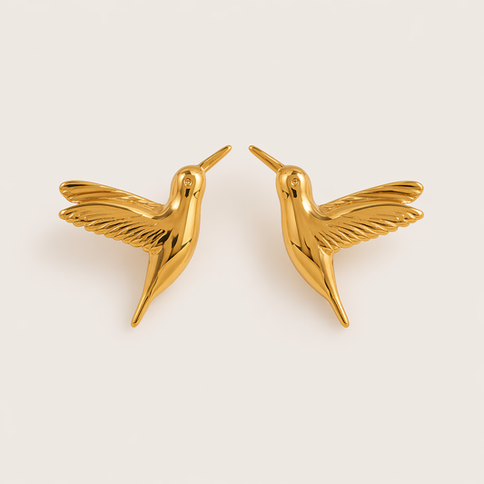 The Kai EARRINGS are gold stud earrings shaped like hummingbirds with detailed feathered wings in flight.