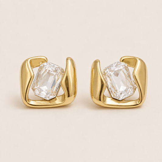 Gold sculptural stud earrings gripping a large emerald-cut white stone in a swirled open frame — Folie à Trois Kaleidoscope EARRINGS