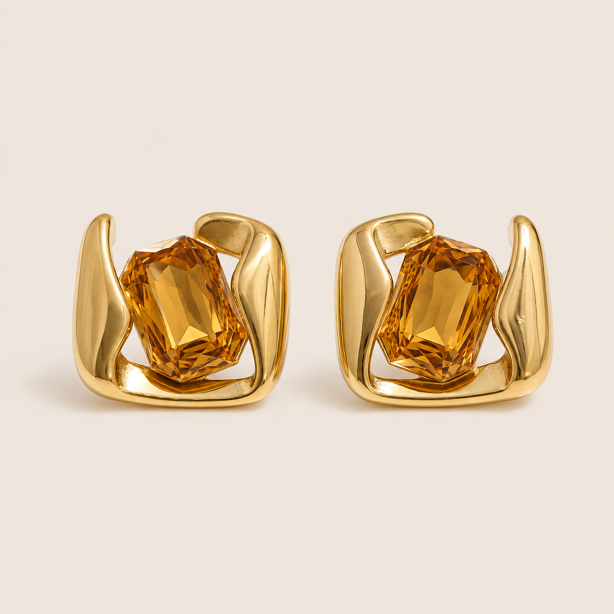 Gold sculptural stud earrings gripping a large emerald-cut champagne stone in a swirled open frame — Folie à Trois Kaleidoscope EARRINGS