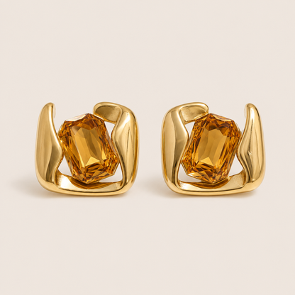 Gold sculptural stud earrings gripping a large emerald-cut champagne stone in a swirled open frame — Folie à Trois Kaleidoscope EARRINGS