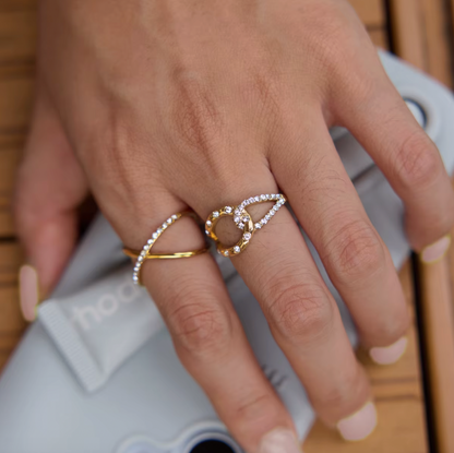 Model rests her hand on a speaker wearing the Kalimera RING stacked with a pavé teardrop ring.