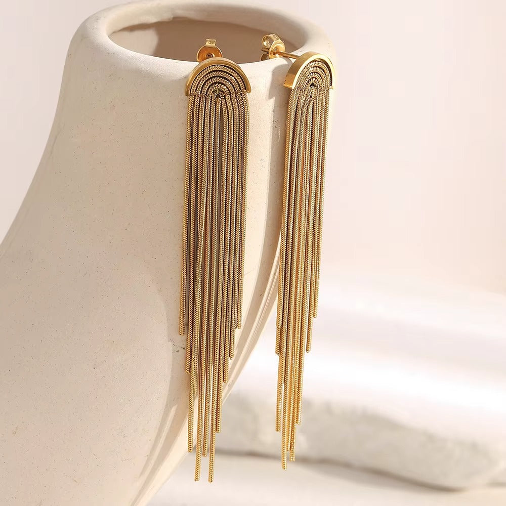 Kiss and Tell Earrings in gold displayed on a ceramic bust, the chain fringe draping down in long strands.