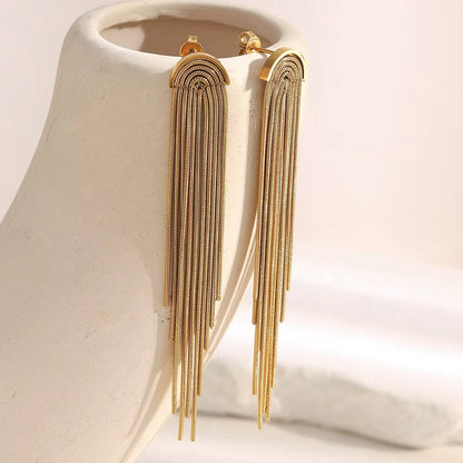 Kiss and Tell Earrings in gold displayed on a ceramic bust, the chain fringe draping down in long strands.