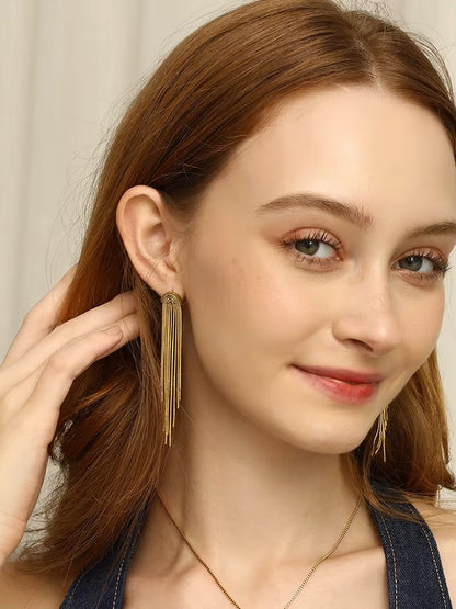 Kiss and Tell Earrings worn by a smiling model, gold chain fringe framing the face on both ears nicely.