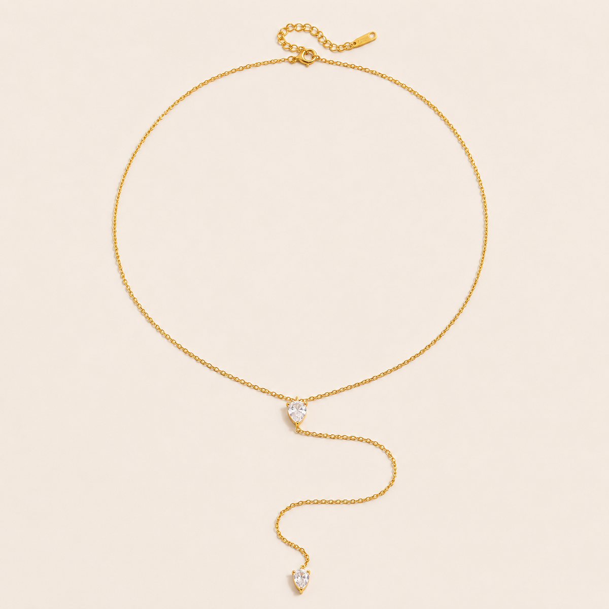 Gold Lariat Y NECKLACE with two pear-shaped crystal accents on a fine chain, drawn into a long drop, laid flat.