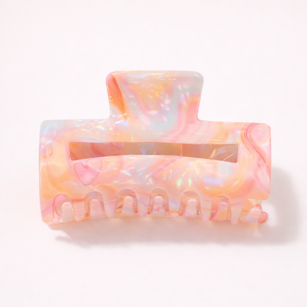 Lark HAIR CLIP large rectangular acetate claw clip in an iridescent peach and pastel pearl pattern, studio shot.
