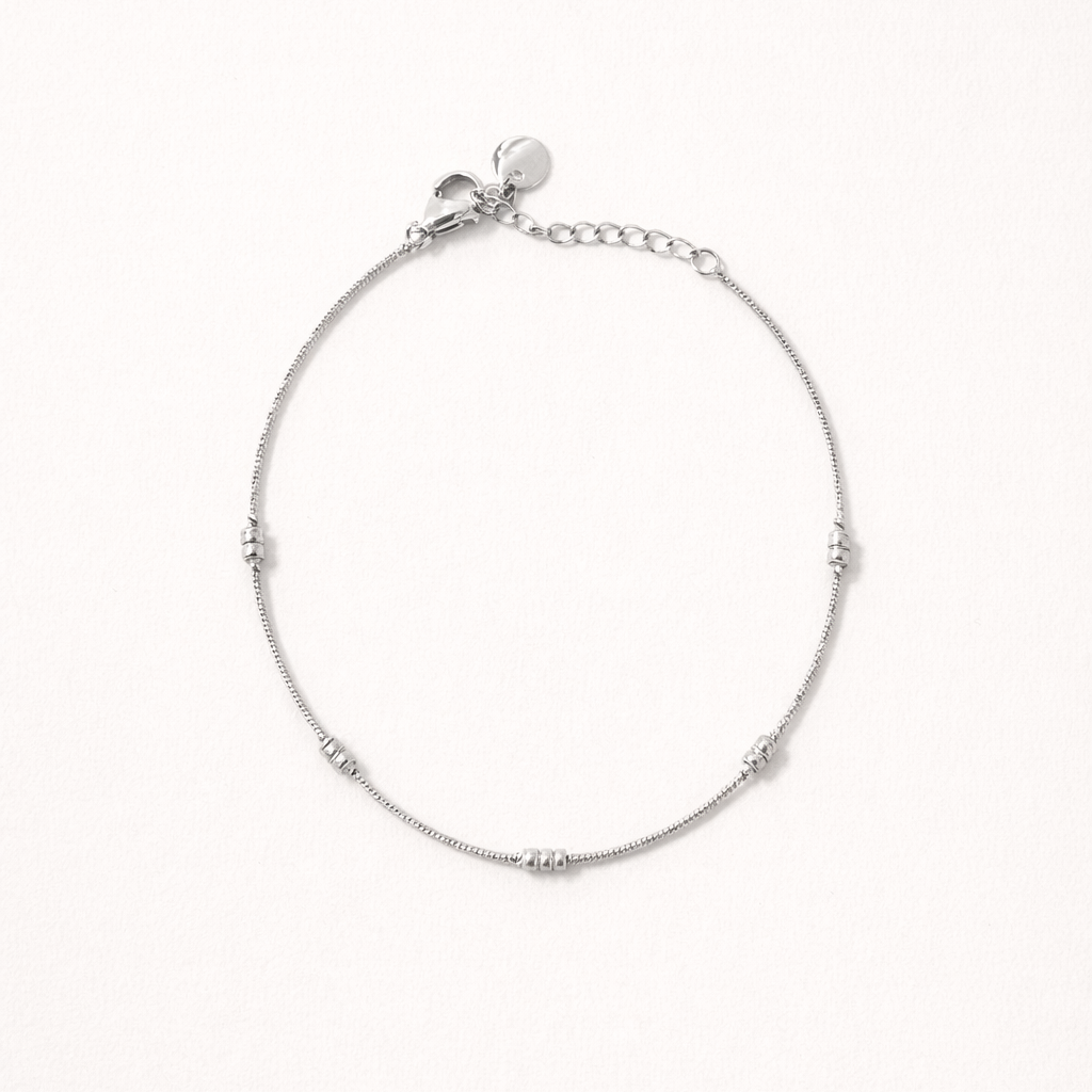 Lay Low BRACELET in silver, delicate chain with small ridged station beads, studio flat-lay on white.