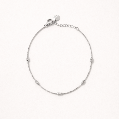 Lay Low BRACELET in silver, delicate chain with small ridged station beads, studio flat-lay on white.