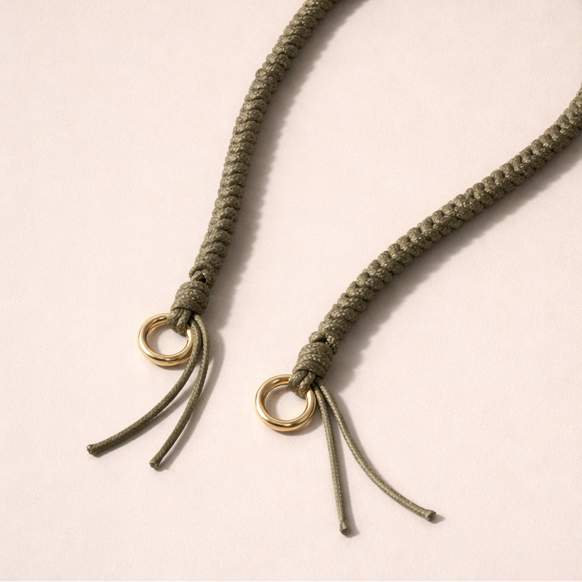 Olive green braided Layover long phone strap, detail view of the gold ring and fringe end.