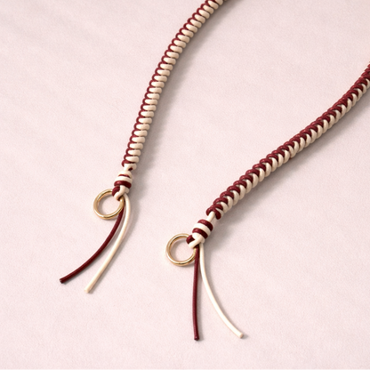 Burgundy and cream two-tone braided Layover strap, close-up of the knotted gold ring and fringe end.