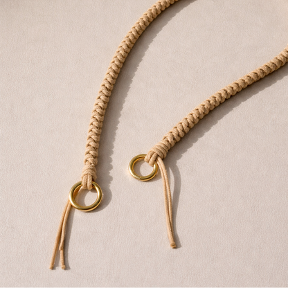 Tan braided Layover long phone strap, close-up of the knotted gold ring and fringe end.