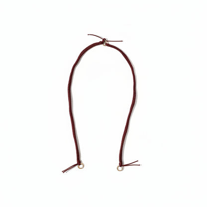 Burgundy braided Layover long phone strap laid out full length on a white background.