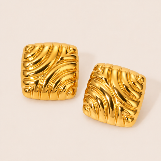 Gold Leia EARRINGS square studs with a swirling, ribbed wave texture and a bold, polished sculptural finish overall.