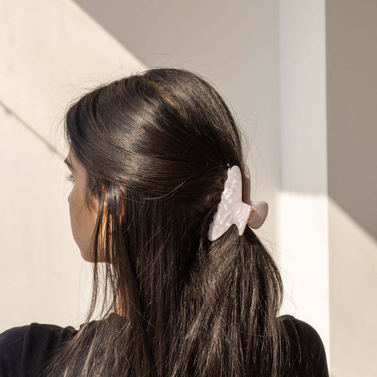 Let's Fall HAIR CLIP's pale lavender claw clip worn in half-up dark hair, in warm sunlight.