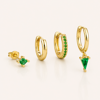 Lexi Set in green, a princess-cut stud, a plain hoop, a pave hoop, and a hoop with a green triangle crystal drop, laid flat.