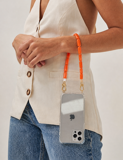 Model wears the orange beaded Lilette strap on her wrist, holding a phone in a clear case.