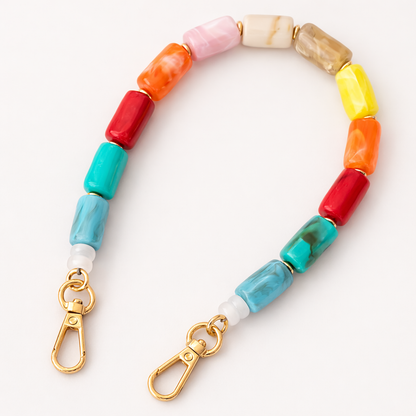 Multicolor beaded Lilette short phone strap in pink, orange, red, teal, and yellow, coiled flat.
