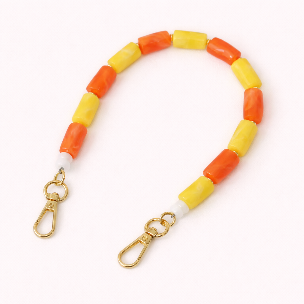 Orange and yellow beaded Lilette short phone strap coiled flat with gold-tone clasp ends.