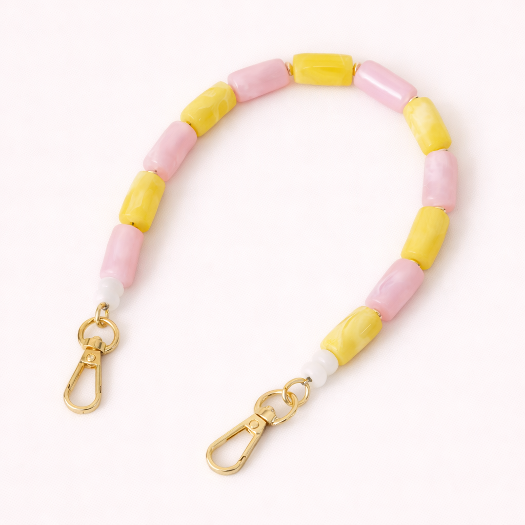 Pink and yellow beaded Lilette short phone strap coiled flat with gold-tone clasp ends.