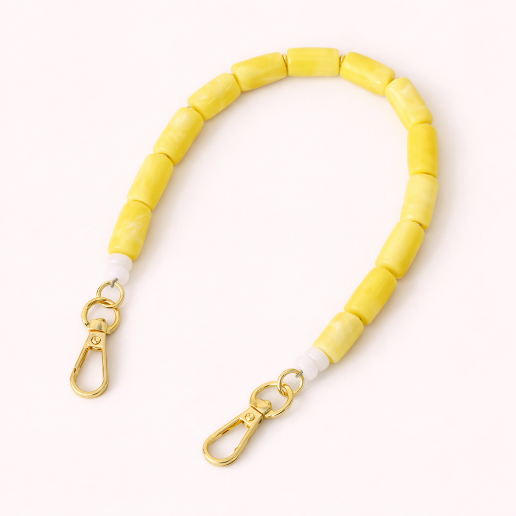 Solid yellow beaded Lilette short phone strap coiled flat with gold-tone clasp ends.