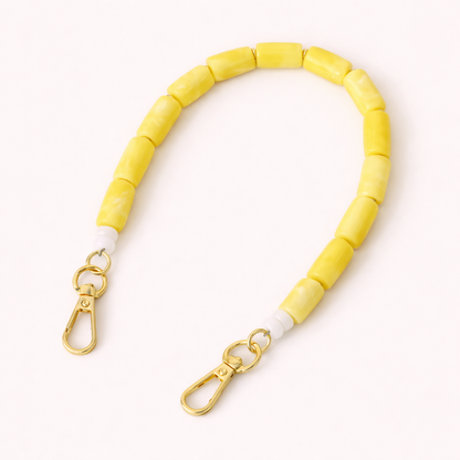 Solid yellow beaded Lilette short phone strap coiled flat with gold-tone clasp ends.