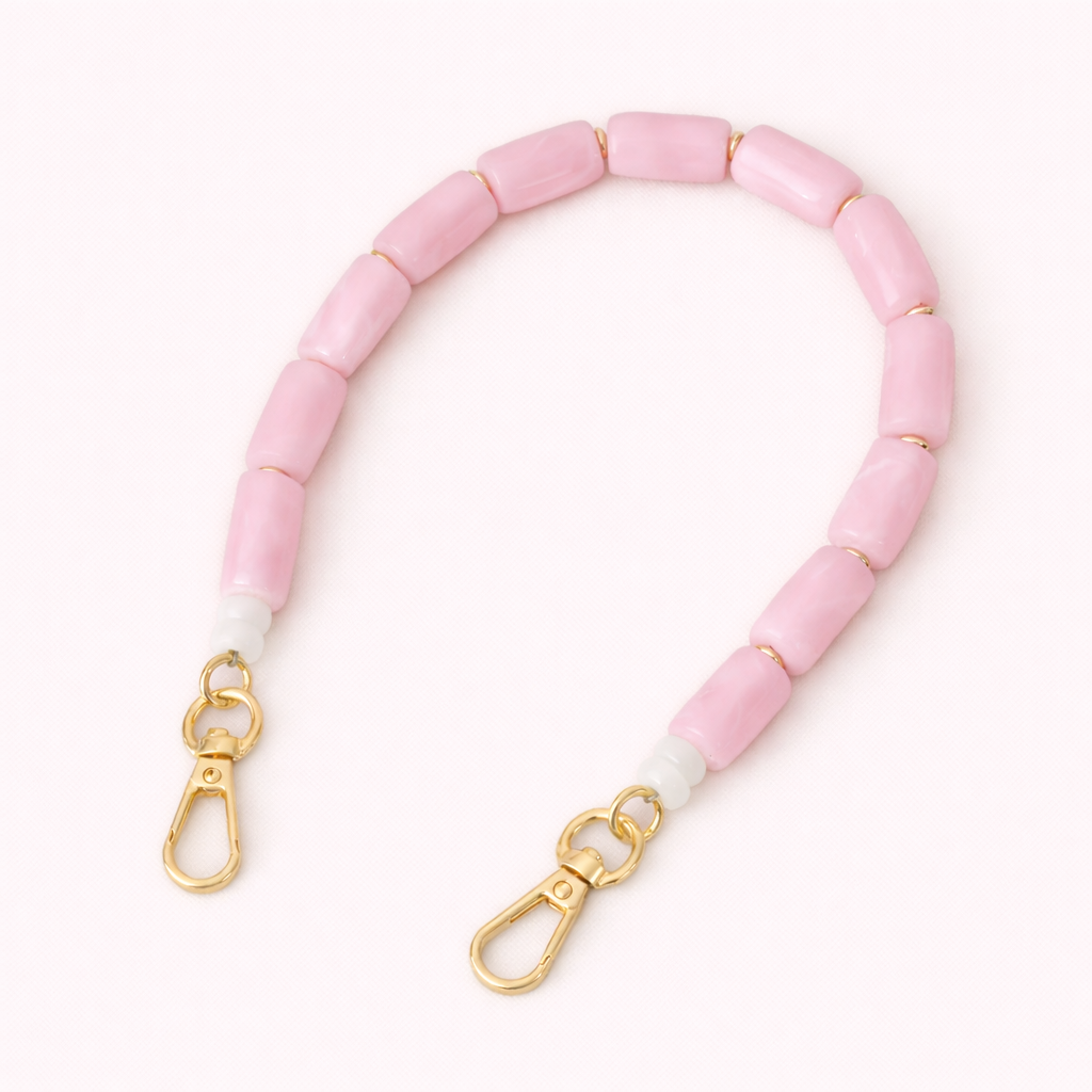 Solid pink beaded Lilette short phone strap coiled flat with gold-tone clasp ends.