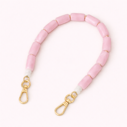 Solid pink beaded Lilette short phone strap coiled flat with gold-tone clasp ends.
