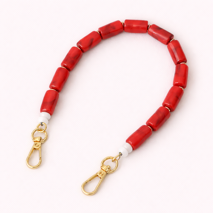 Solid red beaded Lilette short phone strap coiled flat with gold-tone clasp ends.