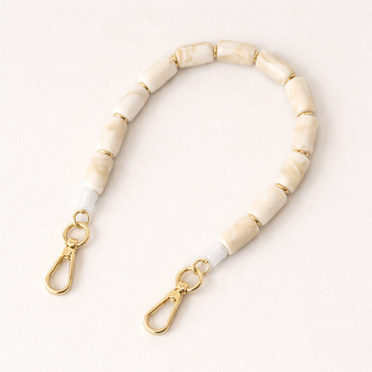 Ivory marbled beaded Lilette short phone strap coiled flat with gold-tone clasp ends.