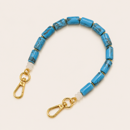 Blue marbled beaded Lilette short phone strap coiled flat with gold-tone clasp ends.