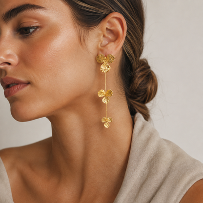 Close-up of the Folie à Trois Litoral EARRINGS, showing the hammered gold trefoil discs cascading along a thin chain.