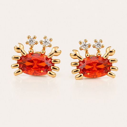 Gold Little Crab EARRINGS stud with an orange oval cubic zirconia body, gold claws and legs, and two small white round accent stones.
