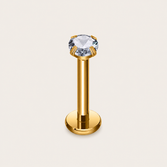 The Little Diamond PIERCING in gold, a labret-style stud with a large round clear gem in a prong setting.