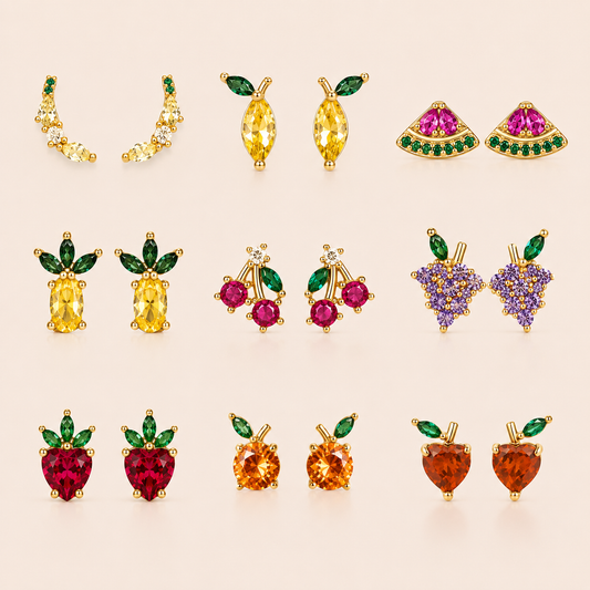 Grid of gold fruit-themed stud earrings from the Little Fruit EARRINGS in nine designs, including cherry, grape, strawberry, and pineapple.