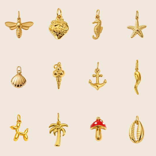 The Little Joys Charms BUNDLE laid flat, showing twelve gold charms including a bee, strawberry, seahorse, starfish, shell, and mushroom.
