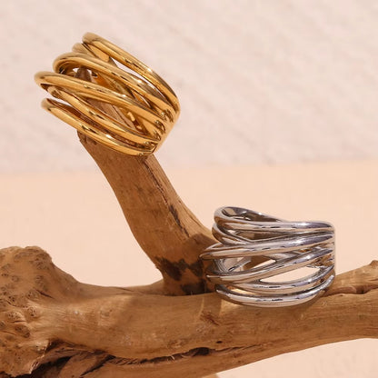 Gold and silver wide wrap-style Lizie RING pieces displayed side by side on a weathered driftwood branch.