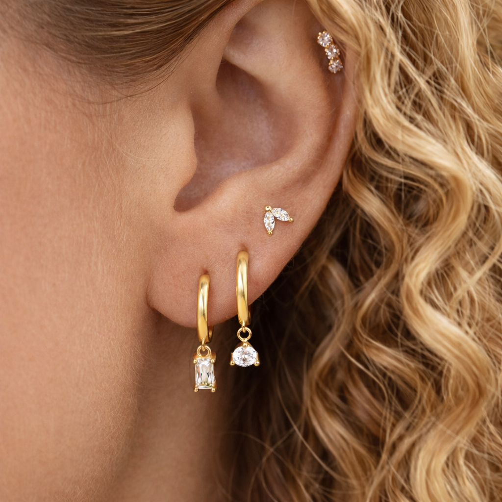 Lola Set worn on the ear, layering a marquise crawler stud with two crystal-drop hoops along the lobe.