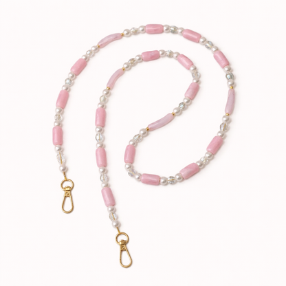 Pink beaded Loreto phone strap coiled flat, accented with pearls, crystals, and gold-tone clasps.