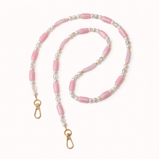 Pink beaded Loreto phone strap coiled flat, accented with pearls, crystals, and gold-tone clasps.
